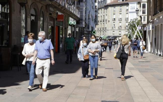Personas andando por la calle con mascarilla.