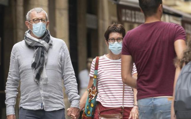Personas andando por la calle con mascarilla para evitar contagios de coronavirus.