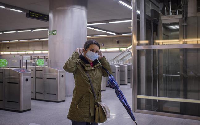 Una mujer mascarilla se pone la mascarilla.