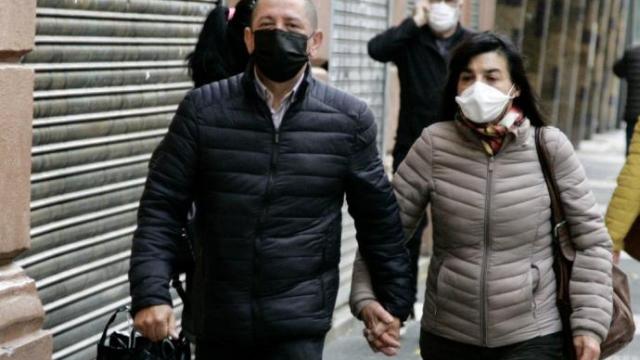 Dos personas pasean con la mascarilla puesta.