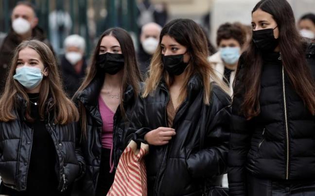 Varias jóvenes paseando con mascarilla.