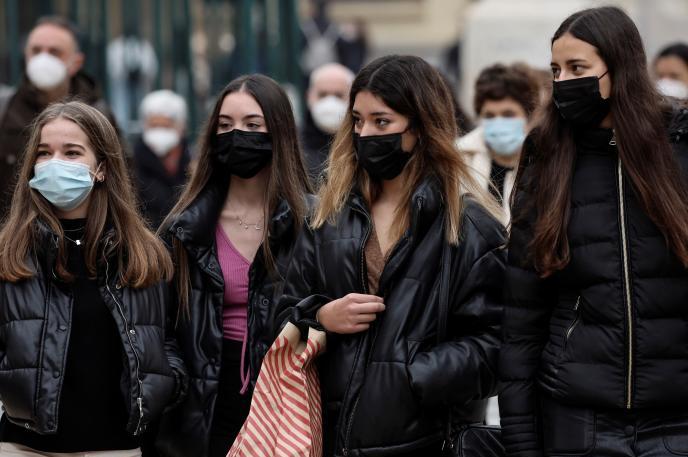 Varias jóvenes paseando con mascarilla.