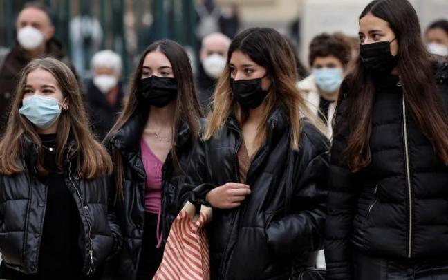 Varias jóvenes paseando con mascarilla.