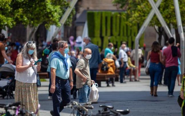 Personas paseando por la calle con mascarilla.
