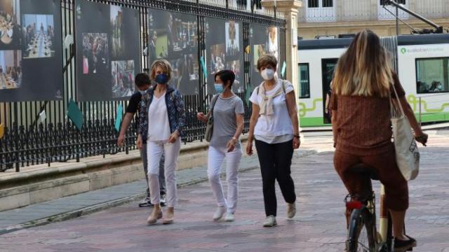 Personas andando por la calle con mascarilla.
