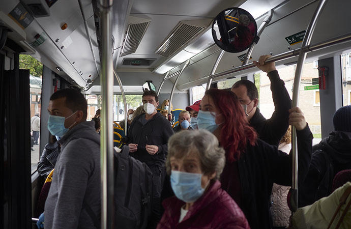 Viajeros con mascarilla dentro de un autobús.