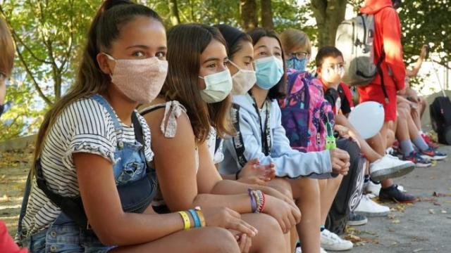 Varios escolares con mascarilla en el recreo.