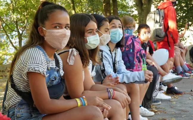 Varios escolares con mascarilla en el recreo.