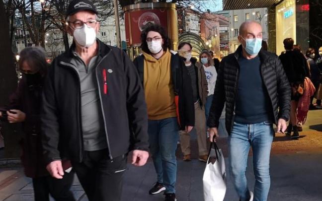 Varias personas pasean con la mascarilla puesta.