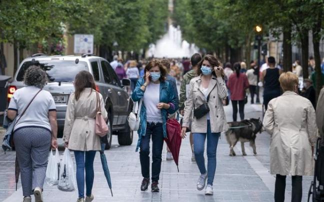 Personas andando por la calle con mascarilla.