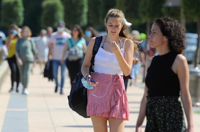 Dos jóvenes pasean por la calle sin mascarilla