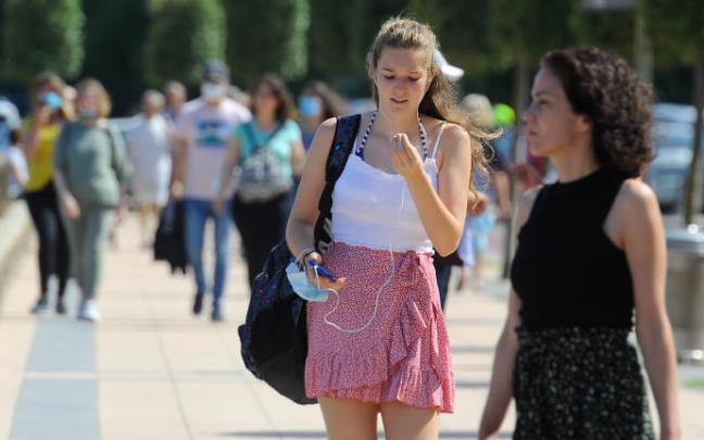 Dos jóvenes pasean por la calle sin mascarilla