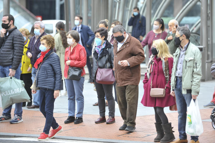 Un grupo de personas llevan mascarilla en la vía pública