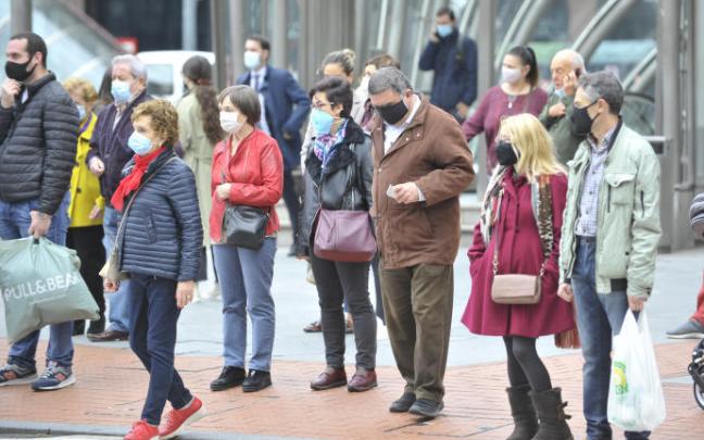 Un grupo de personas llevan mascarilla en la vía pública