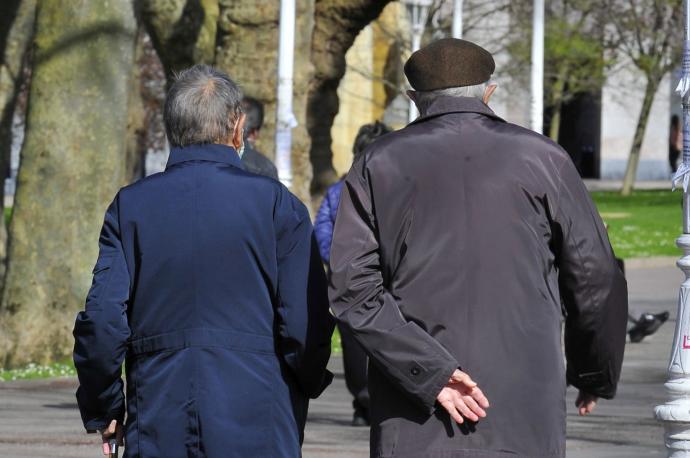 Dos personas mayores pasean por un parque de Bilbao