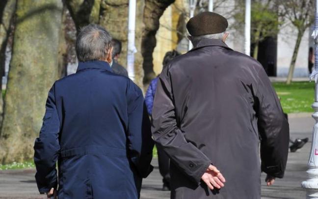 Dos personas mayores pasean por un parque de Bilbao