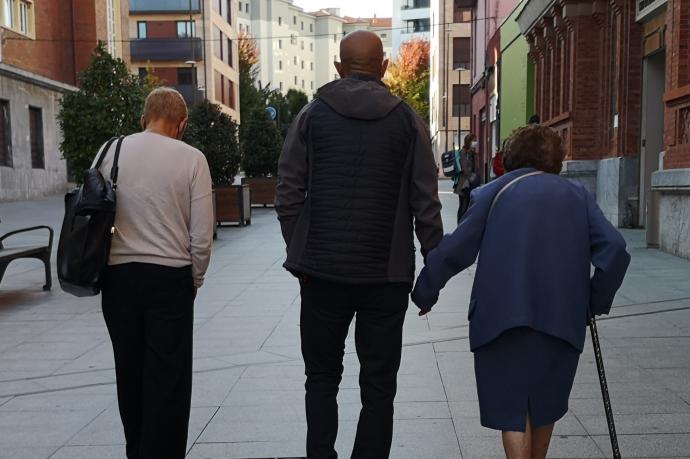 Personas mayores sin relación con la información paseando por la calle.