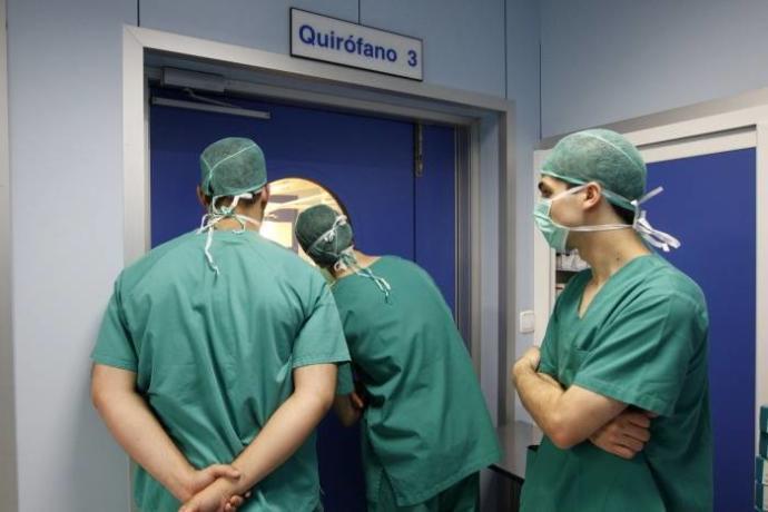 Tres médicos de Osakidetza, frente a un quirófano.