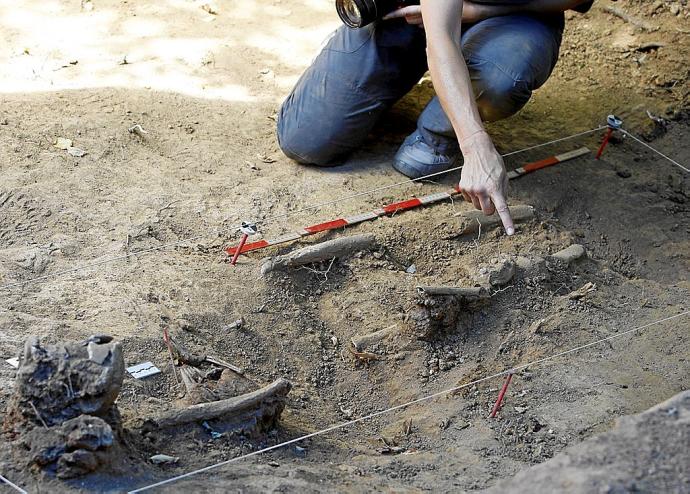 Un operario señala unos restos humanos durante la exhumación de un gudari en una fosa de Mendata (Bizkaia). Foto: Zigor Alkorta