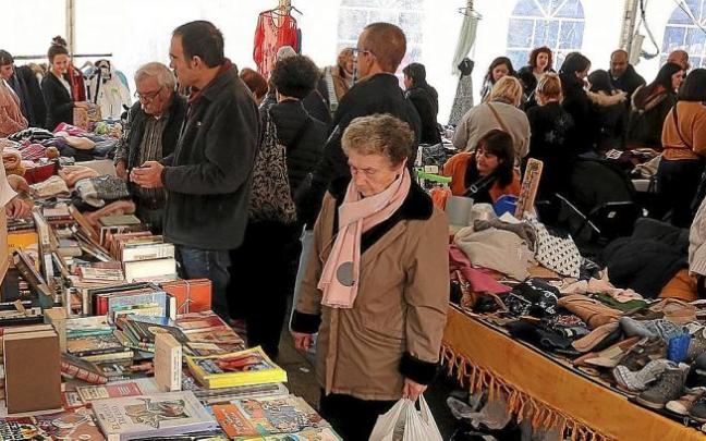 Varias personas en torno a los puestos del primer mercado navideño de segunda mano que se hizo en 2019.