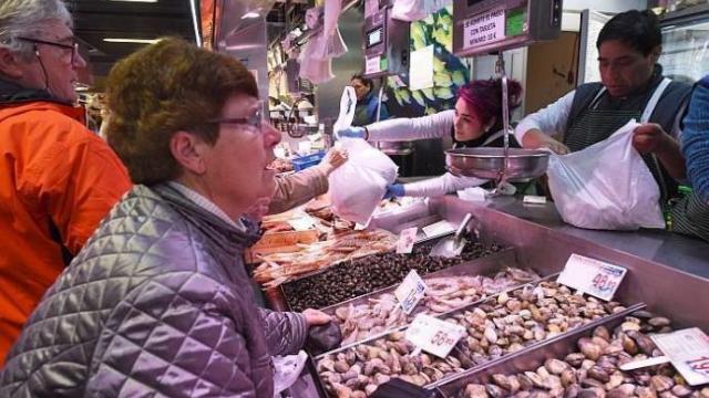 Personas comprando en un puesto de un mercado