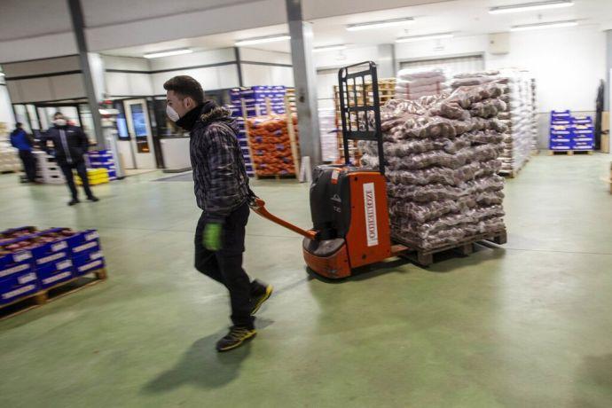 Un trabajador carga alimentos en Mercairuña.