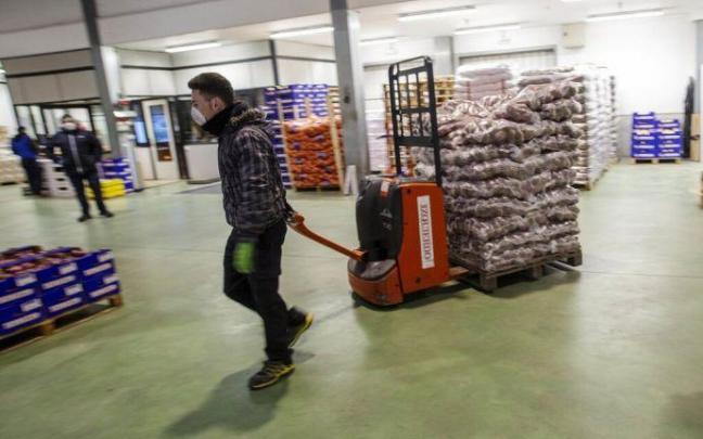 Un trabajador carga alimentos en Mercairuña.