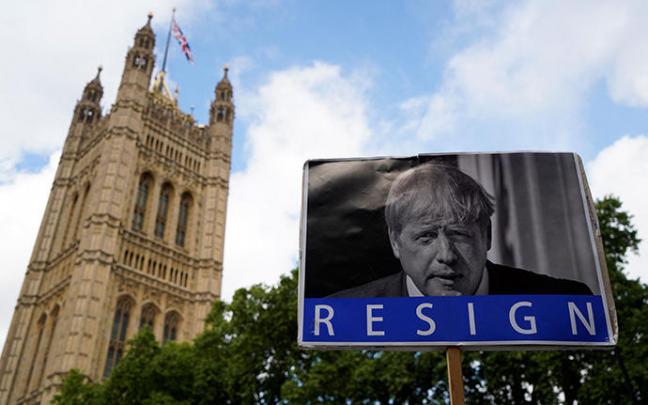 Un cartel pidiendo la dimisión de Johnson ante el Palacio de Westminster.