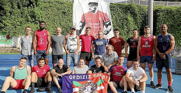 Jugadores, directivos y aficionados posan en Altamira con la bandera del club y la imagen de Kawa Leauma al fondo. Foto: Iker Azurmendi