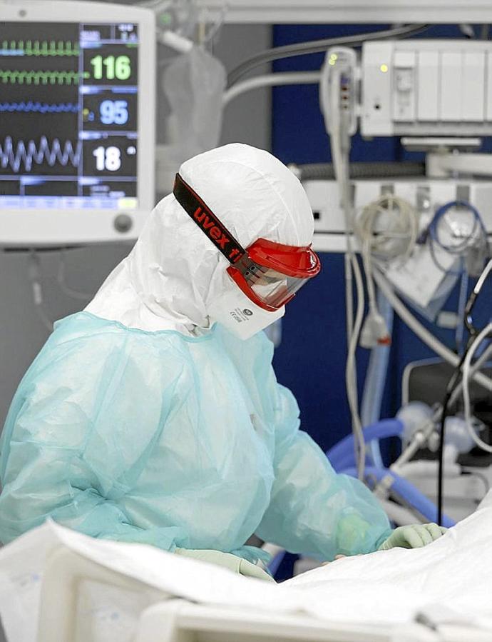 Una sanitaria atiende a un paciente en la UCI. Foto: Efe