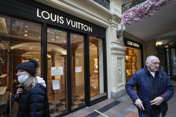 Ciudadanos rusos pasan frente a una tienda cerrada de Louis Vuitton en Moscú.