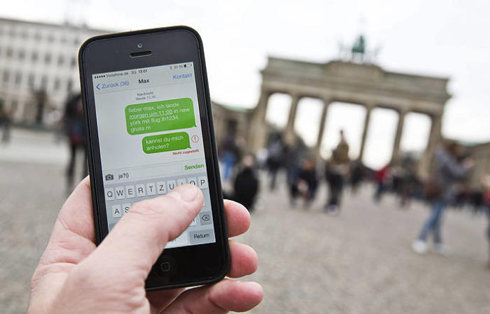 Una persona utiliza su teléfono móvil frente a la Puerta de Brandenburgo, en Berlín.