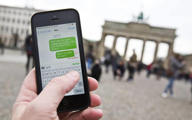 Una persona utiliza su teléfono móvil frente a la Puerta de Brandenburgo, en Berlín.