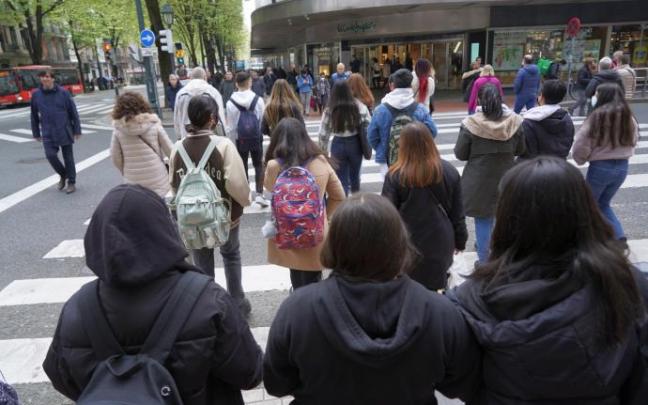 Varias personas cruzan por un paso semafórico céntrico de la capital vizcaina.