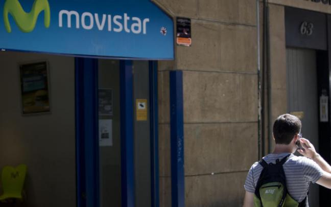 Un usuario pasa por una tienda de Movistar. Un usuario pasa por una tienda de Movistar.