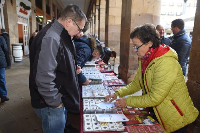 Un cliente mira unos artículos en un puesto de la Plaza Nueva