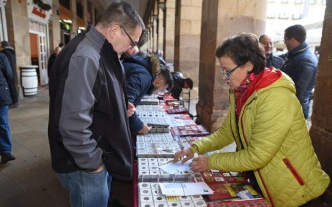Un cliente mira unos artículos en un puesto de la Plaza Nueva Un cliente mira unos artículos en un puesto de la Plaza Nueva