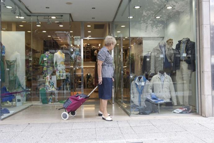 Mujer mirando el escaparate de una tienda de ropa de la calle Gorbea.