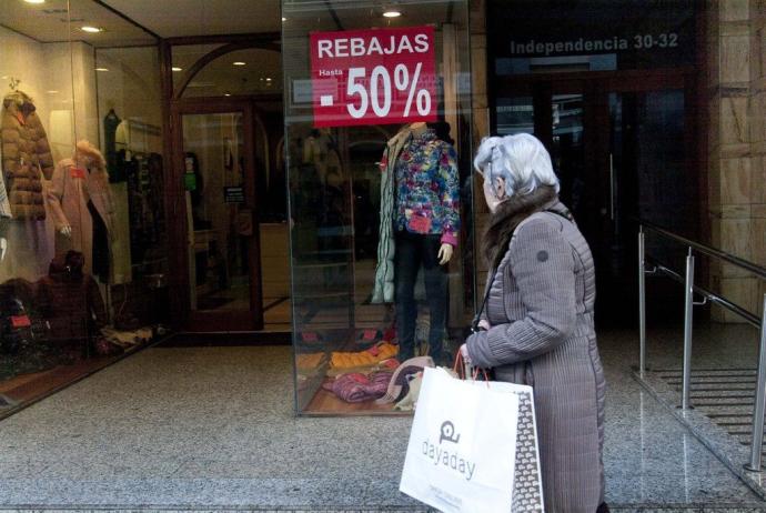 Mujer viendo el escaparate de una tienda de Vitoria.