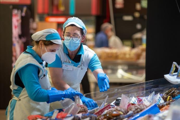 Dos mujeres, trabajando en un supermercado.