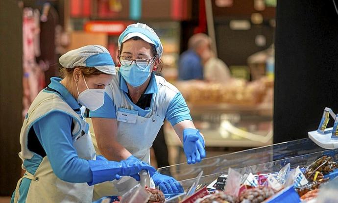 Dos mujeres, en su trabajo diario en un supermercado. Foto: E.P.