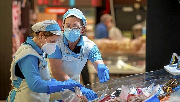 Dos mujeres, en su trabajo diario en un supermercado. Foto: E.P.