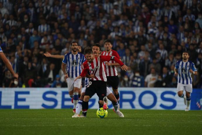 Iker Muniain lucha por hacerse con un balón.