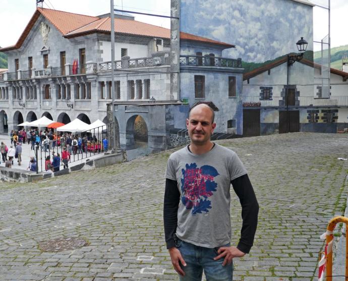 Unai Ruiz Galartza delante del mural que pintado en la pared trasera del frontón de Leitza, un trampantojo muy especial.