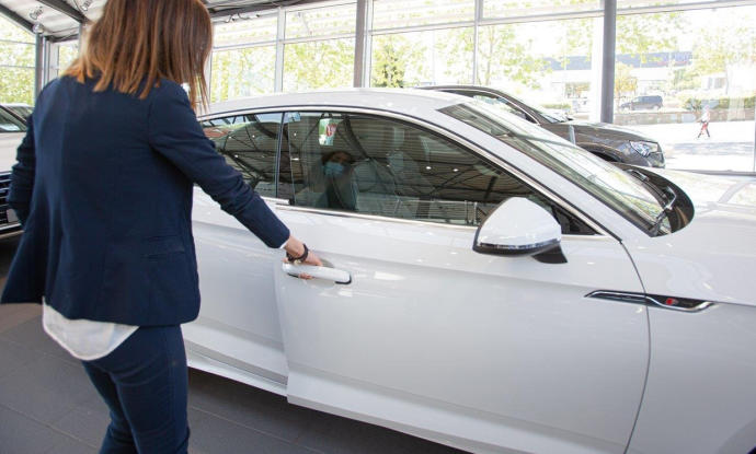 Una mujer abre un coche en un concesionario.