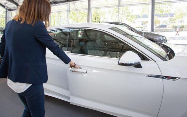 Una mujer abre un coche en un concesionario. Una mujer abre un coche en un concesionario.
