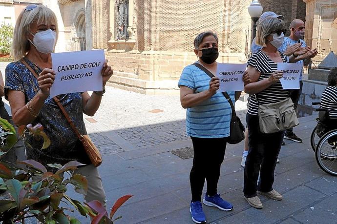 Tres tudelanas protestan contra el campo de golf delante del ayuntamiento.