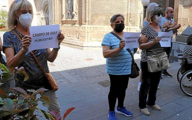 Tres tudelanas protestan contra el campo de golf delante del ayuntamiento.
