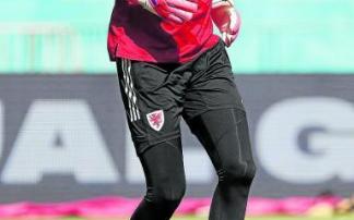 Wayne Hennessey trabaja sobre el césped. Foto: Efe