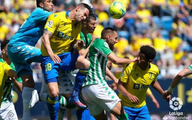 Álvaro Negredo salta a por el balón rodeado por jugadores del Betis.